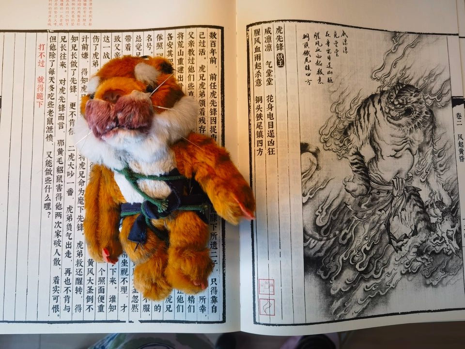 Black Myth Wukong Ying Shen Tu open reference pages beside Wukong plush
