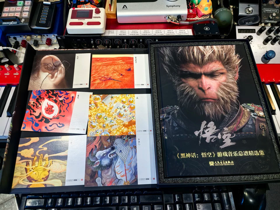 Black Myth Wukong score book book and six scene postcards beside music equipment