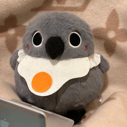 Love and Deepspace Mephisto bird plush with fried egg bib on a laptop