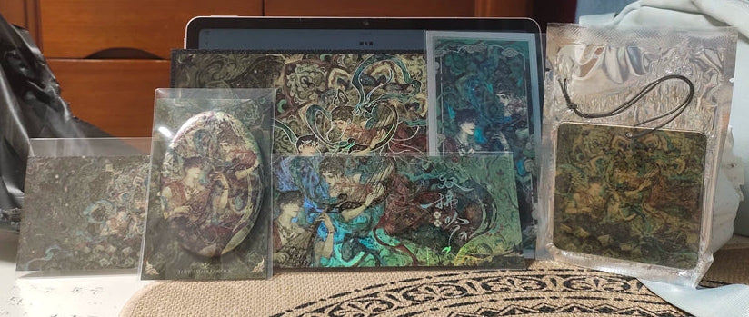 Love and Deepspace Rafayel dual foil set laid out with postcards and prints