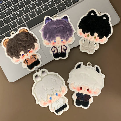 Five Love and Deepspace plush charms arranged beside a laptop