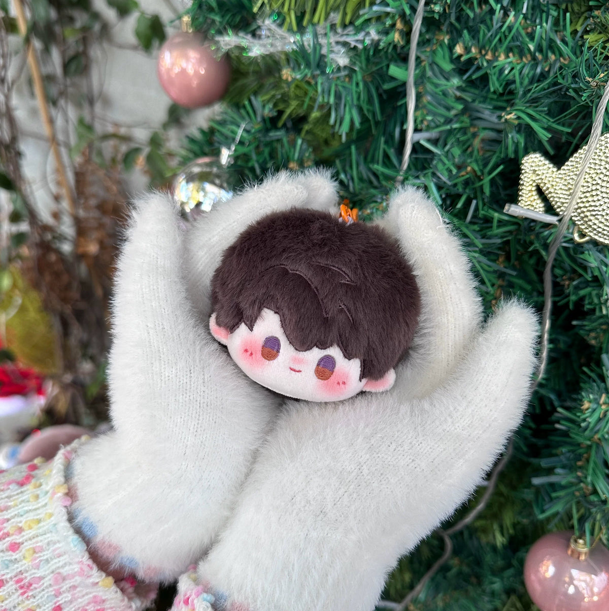 Love and Deepspace round plush doll charm brown hair in front of a Christmas tree