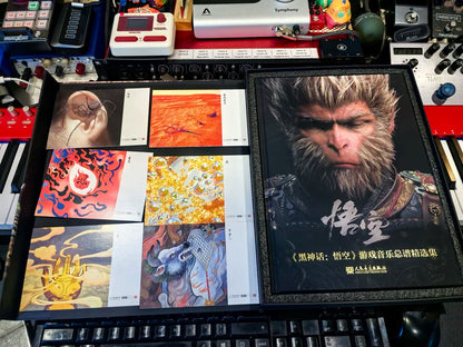 Black Myth Wukong score book book and six scene postcards beside music equipment