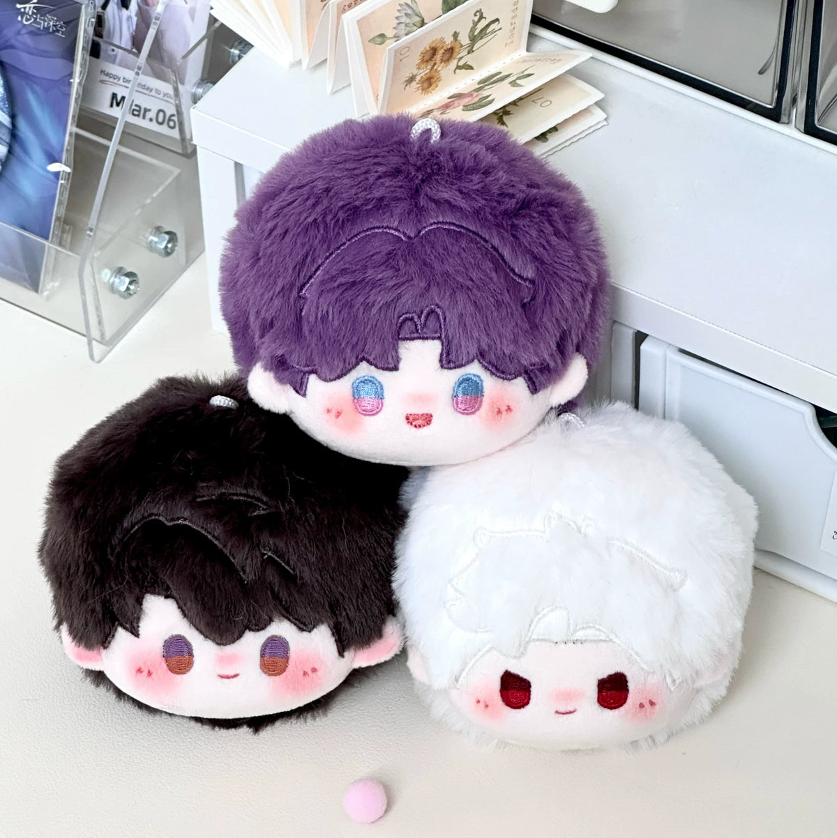 Love and Deepspace round plush doll charms purple, black and white hair stacked together